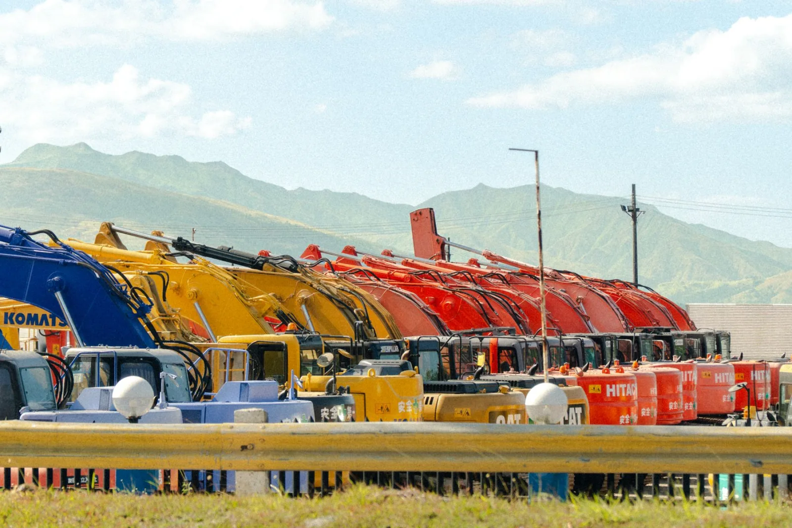 A long row of heavy machines lined up in a yard.