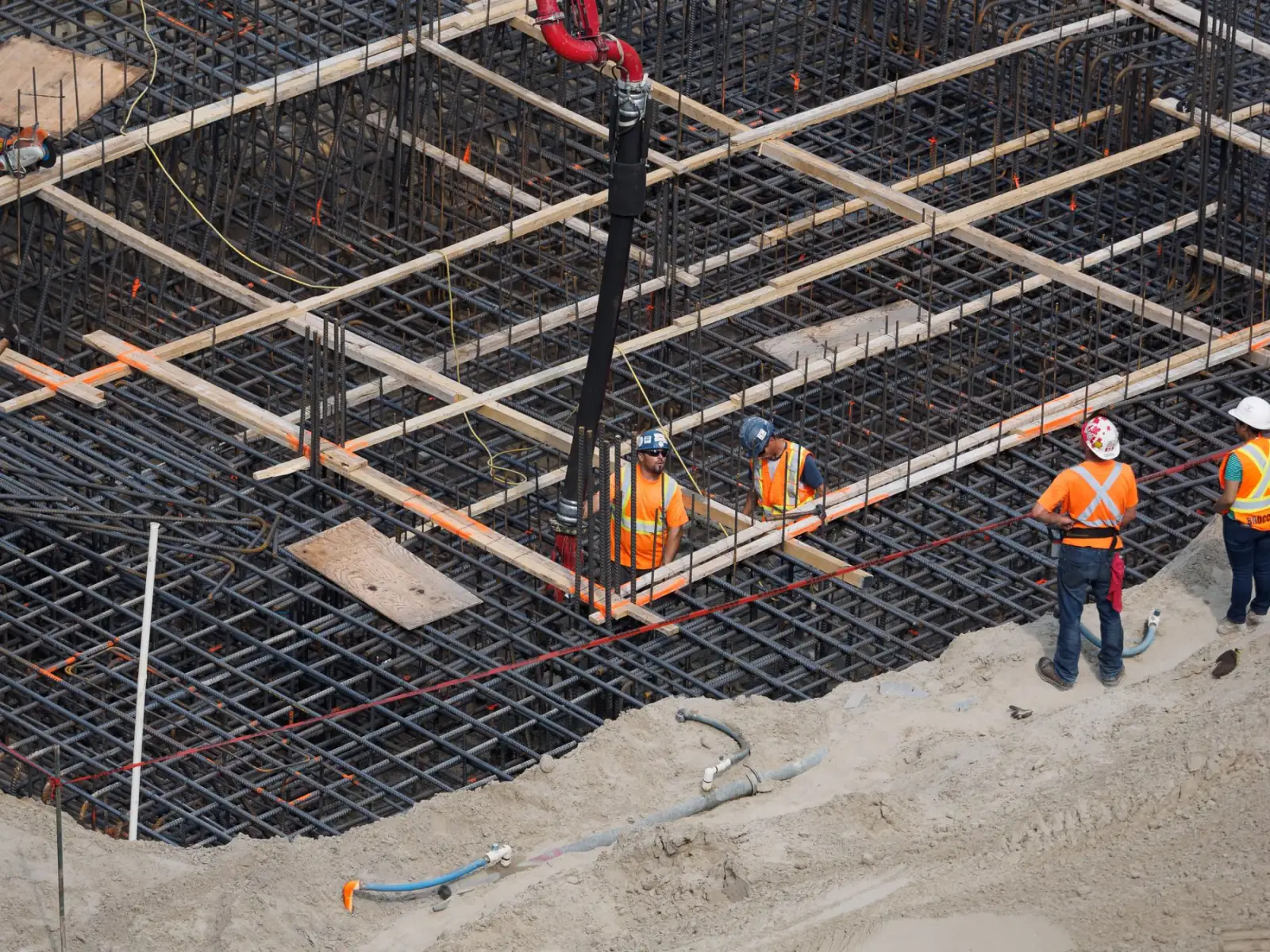A reinforced concrete deck under construction with a crane overhead.
