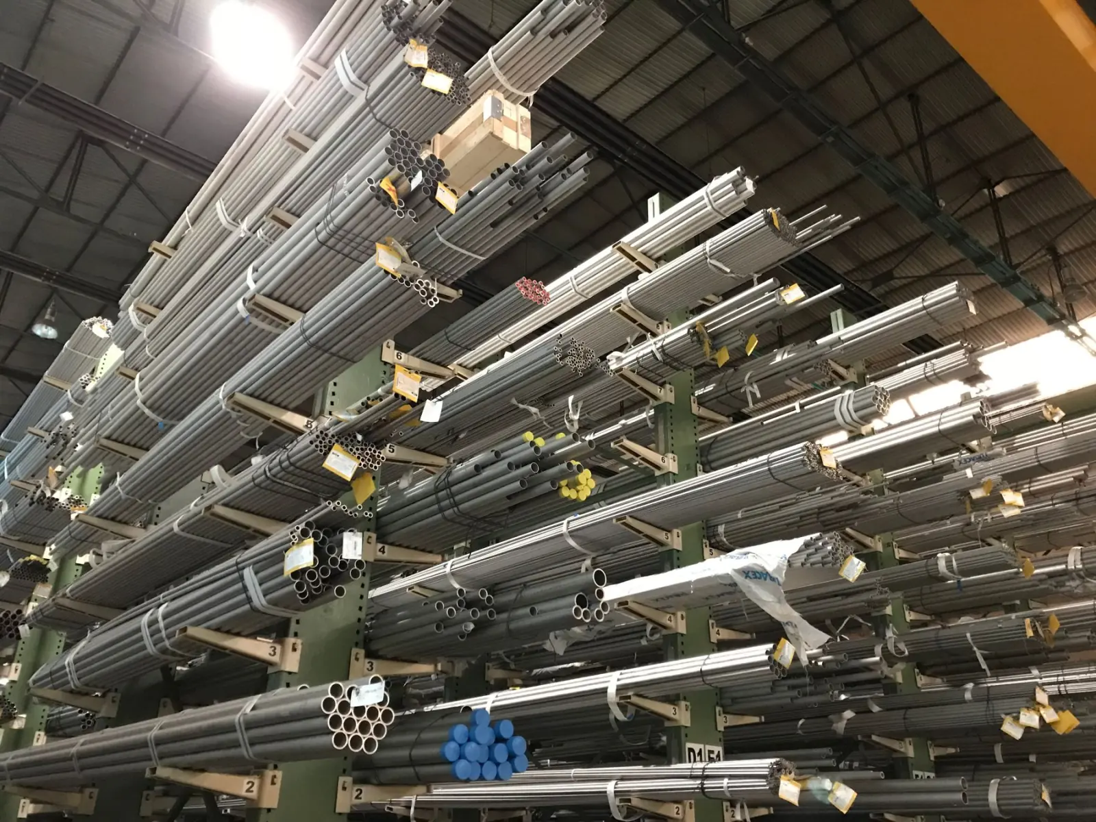 Cantilever racks loaded with steel bar and tube stock.